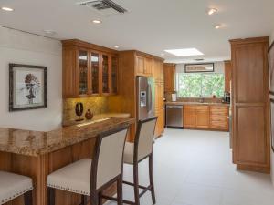 uma cozinha com armários de madeira e um bar com bancos em Hidden Haven em Palm Springs