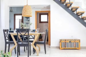 a dining room with a wooden table and black chairs at Villa Kora in Kallithea Rhodes