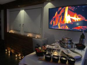 a table with food and a tv on a wall at Mountainsuite in Oberwald