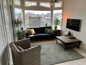 a living room with a couch and a table at Villa Rose in Bergum