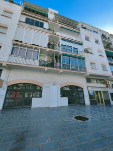 un grande edificio con porte e balcone di Casa Bella Apartment BY NAMASTE ELITE a Torremolinos