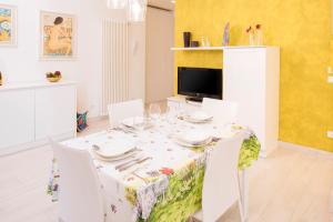 a dining room with a white table and chairs at DALIAHOUSE Bardolino family and cozy apartment in Bardolino