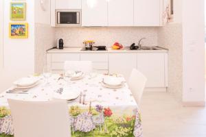 a white kitchen with a table and chairs in a room at DALIAHOUSE Bardolino family and cozy apartment in Bardolino