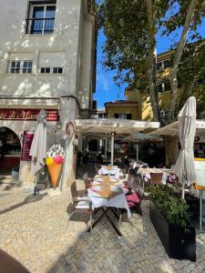 a patio with tables and umbrellas in front of a building at one bedroom Cascais historic center Nomad Dreams N 3 in Cascais