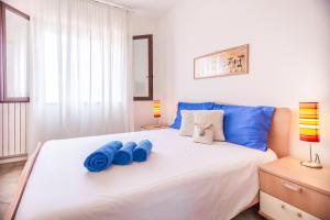a bedroom with a bed with blue pillows on it at Orange Villasimius House in Villasimius