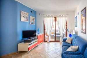 a blue living room with a blue couch and a tv at Orange Villasimius House in Villasimius