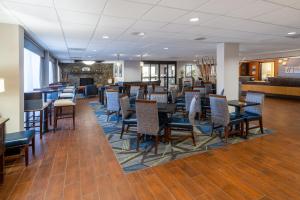 a restaurant with chairs and tables and a bar at Holiday Inn Express Forsyth, an IHG Hotel in Forsyth