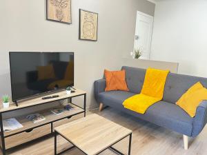 普羅旺斯艾克斯的住宿－L'Aristide，客厅配有蓝色的沙发和电视