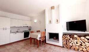 a kitchen and dining room with a table and a fireplace at Appartamento Campagnano in Maccagno Superiore