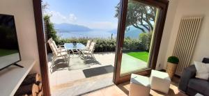 a sliding glass door leading to a patio with a table and chairs at Appartamento Campagnano in Maccagno Superiore