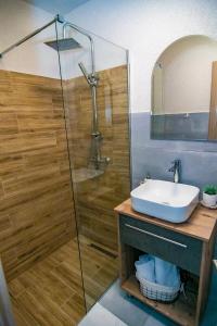 een badkamer met een wastafel en een glazen douche bij Casa AdiMan in Vama Veche