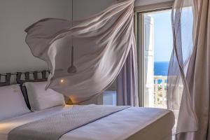 a bedroom with a bed and a large window at Ethereal Villa Mykonos in Kalafatis +21 photos
