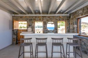 カラファティスにあるEthereal Villa Mykonosのキッチン(椅子と窓のあるバー付)