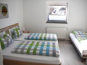 2 camas individuales en una habitación con ventana en Ferienhaus Anni en Leipheim
