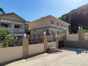 a house with a fence in front of it at La Residence D'Almée Apartment and Studio in Praslin
