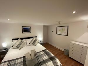 una camera da letto con un grande letto bianco con cuscini di Westons Hideaway, 2 Bed, Free Parking, 6 mins walk to beach, a Weston-super-Mare