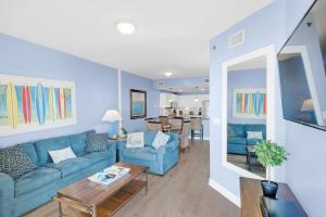 a living room with a blue couch and a table at Grand Panama 2-705 in Panama City Beach
