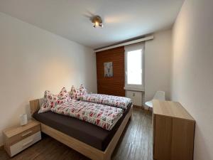 um quarto com uma cama e uma janela em Ferienwohnung Dorfzentrum em Disentis