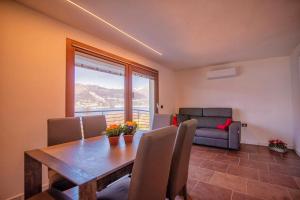 a dining room with a table and a couch at CASA ANGELA in Dervio