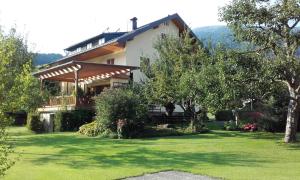 ein Haus mit grünem Rasen davor in der Unterkunft Family- Home Alpenblick in Dellach im Drautal