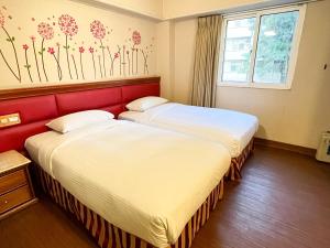 duas camas sentadas uma ao lado da outra num quarto em Spring Art Hotel em Kaohsiung