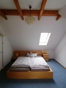 - une chambre mansardée avec un grand lit dans l'établissement Ferienhaus am Grünen Stadtrand, à Dresde