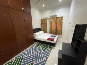 Kleines Zimmer mit einem Bett und einem Teppich in der Unterkunft Homestay Bidor DMaju in Bidur