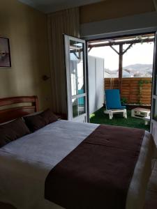 1 dormitorio con 1 cama y balcón con silla en Hostal Stella Del Mare, en Camariñas