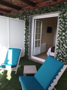 a patio with a blue chair and a mirror at Hostal Stella Del Mare in Camariñas