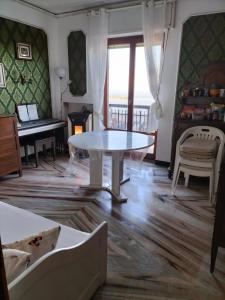 sala de estar con mesa y piano en La Mouette, en Porto San Giorgio