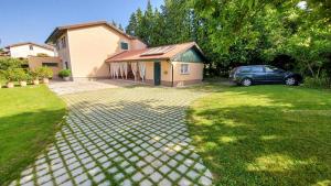 a house with a car parked in front of a driveway at Apartment Otava in Šempas