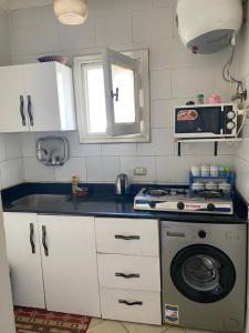 een keuken met een fornuis en een wasmachine bij Delta Sharm Apartment 156 flat 102 in Sharm El Sheikh