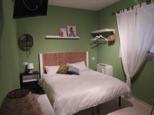 1 dormitorio con 1 cama con sábanas blancas y paredes verdes en B&B Rifugio Della Luna, en Satriano di Lucania