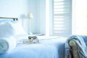 un par de gafas sentadas encima de una cama en Soul Searchers en Jeffreys Bay