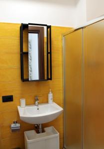 ein Badezimmer mit einem Waschbecken, einem Spiegel und einem WC in der Unterkunft Case Carà 128, Appartamentini nel cuore di Bagheria, Piano Primo in Bagheria