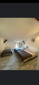 Duas camas num quarto com uma parede em La Cigogne em Éclaron