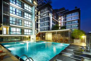 a large swimming pool in the middle of a building at The Plimplace Hotel in Bang Su
