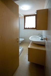 La salle de bains est pourvue d'un lavabo, de toilettes et d'une fenêtre. dans l'établissement San Zeno Apartments, à Vérone