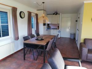 a kitchen and dining room with a table and chairs at Butenskuur in Hollum
