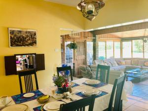 a dining room with a table and a living room at Su Casa Scottsville in Pietermaritzburg