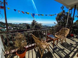 a balcony with two chairs and a table at Redeem Cafe & Homestay in McLeod Ganj