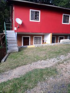 una casa roja con una escalera delante de ella en residencial Remanso, en Florianópolis