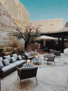 un patio avec des canapés et des tables dans un bâtiment dans l'établissement Santa María Briones, à Briones