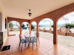 eine Terrasse mit einem Tisch und Stühlen in einem Gebäude in der Unterkunft Casa Rural Fuente de la Higuera in Ronda
