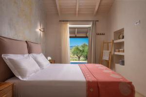 sypialnia z dużym łóżkiem i oknem w obiekcie Villa Carvella - A Sublimely Relaxing Escape! w mieście Tsilivi +37 zdjęć