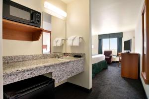 a hotel room with a bathroom with a sink at Travelodge by Wyndham Bill WY Thunder Basin Ntl Grassland in Bill