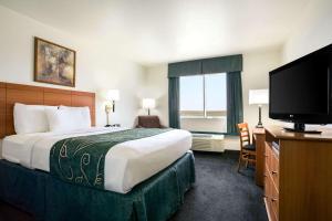 a hotel room with a bed and a flat screen tv at Travelodge by Wyndham Bill WY Thunder Basin Ntl Grassland in Bill