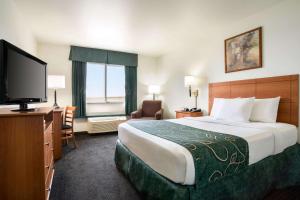 a hotel room with a large bed and a flat screen tv at Travelodge by Wyndham Bill WY Thunder Basin Ntl Grassland in Bill