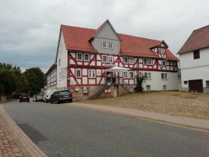 um grupo de edifícios vermelhos e brancos numa rua em Wollröder Krug em Guxhagen