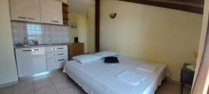 a small bedroom with a white bed and a kitchen at Apartments Toni in Srima